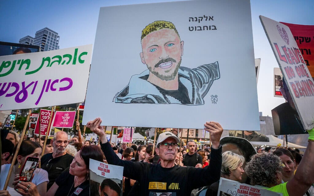 מפגין בתל אביב נושא שלט שעליו דיוקנו של אלקנה בוחבוט, 31 במאי 2025 (צילום: אבשלום ששוני/פלאש90) מפגין בתל אביב נושא שלט שעליו דיוקנו של אלקנה בוחבוט, 31 במאי 2025 (צילום: אבשלום ששוני/פלאש90)