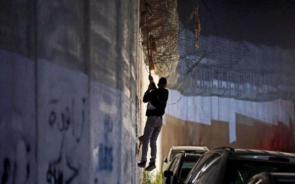 פלסטיני יורד בחבל מגדר ההפרדה בדרכו לשכונת בית חנינא שבמזרח ירושלים, 18 במאי 2025 (צילום: AHMAD GHARABLI / AFP) פלסטיני יורד בחבל מגדר ההפרדה בדרכו לשכונת בית חנינא שבמזרח ירושלים, 18 במאי 2025 (צילום: AHMAD GHARABLI / AFP)