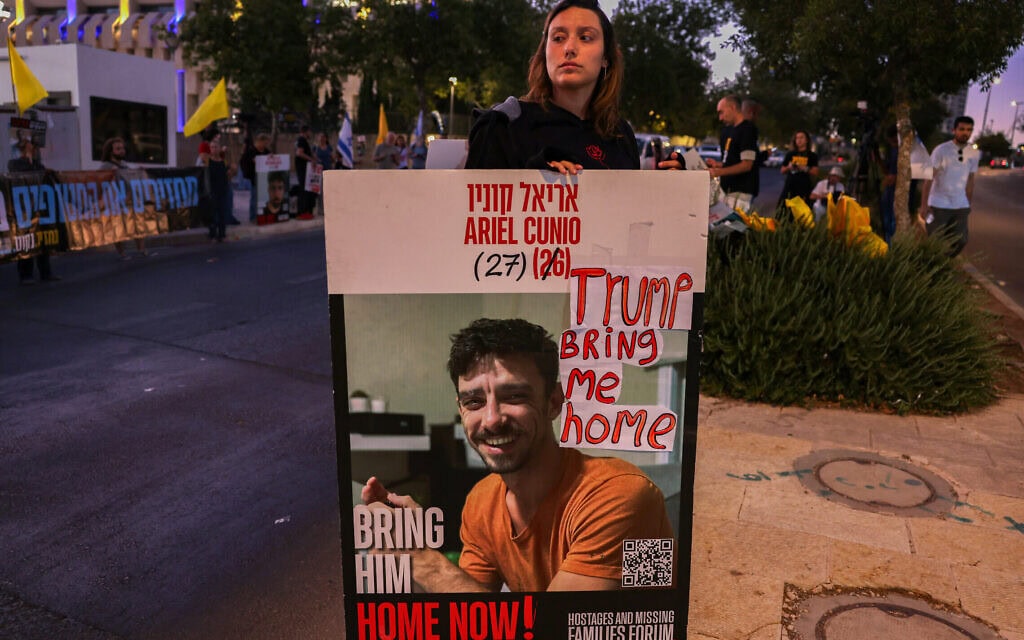 מפגינה נושאת את תמונתו של אריאל קוניו, המוחזק בשבי, בהפגנה למען שחרור החטופים שברצועת עזה, ליד בית ראש הממשלה בירושלים, 13 ביולי 2025 (צילום: HAZEM BADER / AFP) מפגינה נושאת את תמונתו של אריאל קוניו, המוחזק בשבי, בהפגנה למען שחרור החטופים שברצועת עזה, ליד בית ראש הממשלה בירושלים, 13 ביולי 2025 (צילום: HAZEM BADER / AFP)