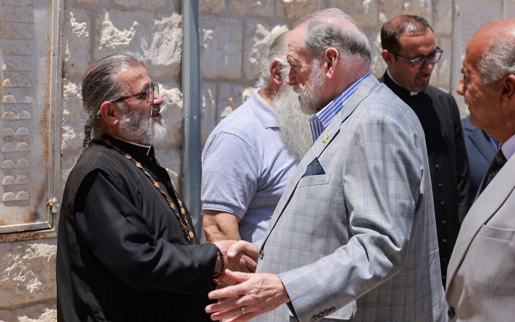 שגריר ארה"ב בישראל, מייק האקבי (במרכז), לוחץ את ידו של האב דאוד ח'ורי מהכנסייה היוונית-אורתודוקסית במהלך ביקורו בעיירה הפלסטינית-הנוצרית טייבה שבגדה המערבית, 19 ביולי 2025 (צילום: Jaafar ASHTIYEH / AFP) שגריר ארה"ב בישראל, מייק האקבי (במרכז), לוחץ את ידו של האב דאוד ח'ורי מהכנסייה היוונית-אורתודוקסית במהלך ביקורו בעיירה הפלסטינית-הנוצרית טייבה שבגדה המערבית, 19 ביולי 2025 (צילום: Jaafar ASHTIYEH / AFP)