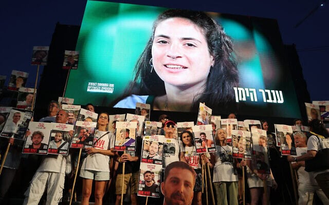 תמונתה של ענבר הימן, שגופתה מוחזקת ברצועת עזה, מוצגת על המסך בהפגנה בתל אביב למען שחרור החטופים, 26 ביולי 2025 (צילום: Jack GUEZ / AFP) תמונתה של ענבר הימן, שגופתה מוחזקת ברצועת עזה, מוצגת על המסך בהפגנה בתל אביב למען שחרור החטופים, 26 ביולי 2025 (צילום: Jack GUEZ / AFP)