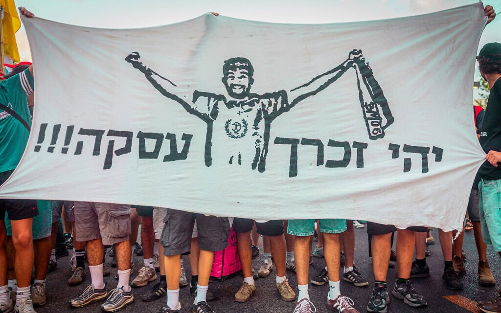 מפגינים בעצרת בתל אביב הקוראת לשחרור החטופים מחזיקים בשלט לזכרו של הרש גולדברג-פולין שנרצח בשבי חמאס, 17 באוגוסט 2025 (צילום: חיים גולדברג/פלאש90)
