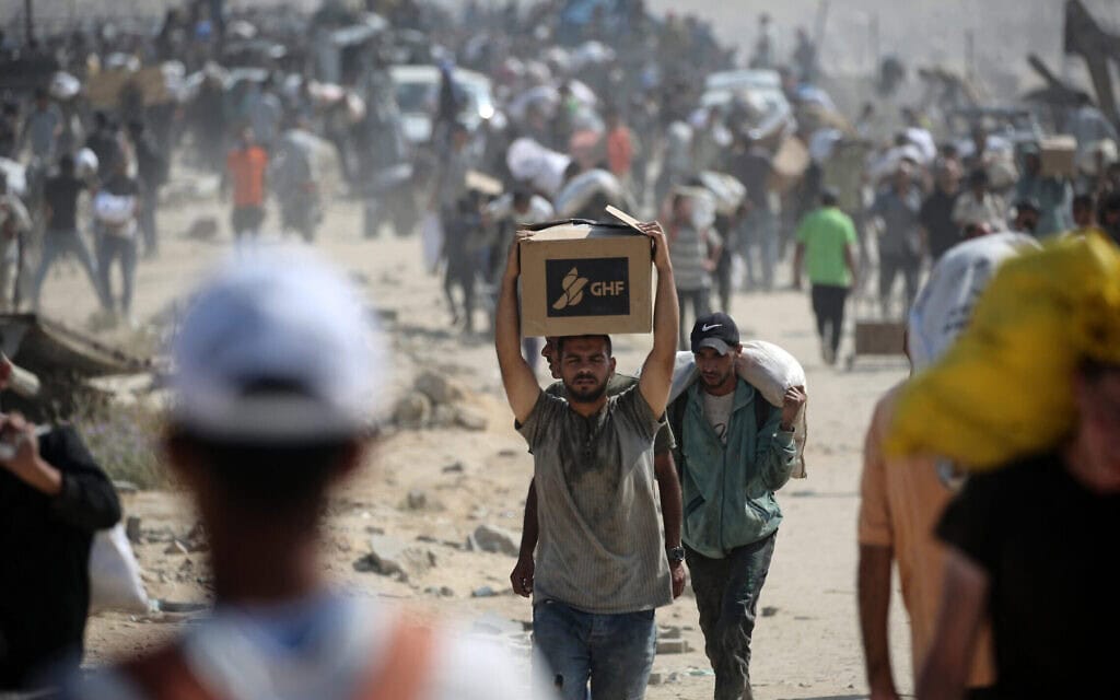 פלסטינים עם סיוע הומניטרי שקיבלו במרכז חלוקה שמפעילה קרן הסיוע לעזה (GHF), 2 באוגוסט 2025 (צילום: Eyad BABA / AFP) פלסטינים עם סיוע הומניטרי שקיבלו במרכז חלוקה שמפעילה קרן הסיוע לעזה (GHF), 2 באוגוסט 2025 (צילום: Eyad BABA / AFP)