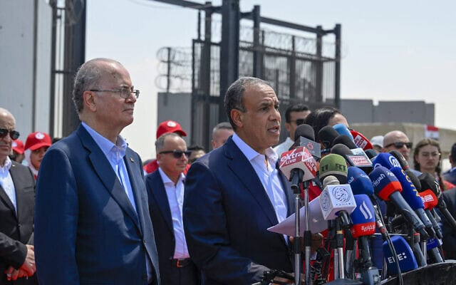 ראש ממשלת הרשות הפלסטינית מוחמד מוסטפא מאזין לדברי שר החוץ המצרי בדר עבד אל־עאטי במסיבת עיתונאים בצד המצרי של מעבר רפיח, 18 באוגוסט 2025