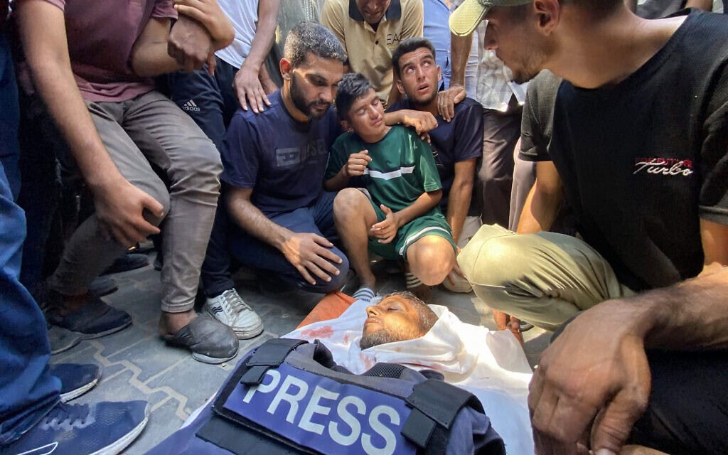 חבריו של חוסאם אל־מסרי, קבלן של רויטרס שנהרג בתקיפה ישראלית על בית החולים נאסר בחאן יונס שבדרום רצועת עזה, מתאבלים על גופתו לפני הלווייתו ב־25 באוגוסט 2025 (צילום: AFP) חבריו של חוסאם אל־מסרי, קבלן של רויטרס שנהרג בתקיפה ישראלית על בית החולים נאסר בחאן יונס שבדרום רצועת עזה, מתאבלים על גופתו לפני הלווייתו ב־25 באוגוסט 2025 (צילום: AFP)