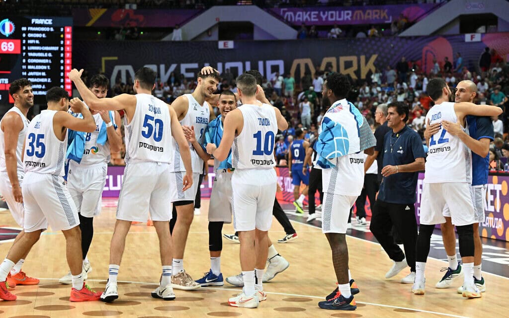 נברת ישראל בכדורסל חוגגת את עלייתה לשמינית גמר אליפות אירופה בכדורסל, אחרי שהביסה את נברת צרפת באצטדיון קטוביץ בפולין, 31 באוגוסט 2025 (צילום: Sergei GAPON / AFP)