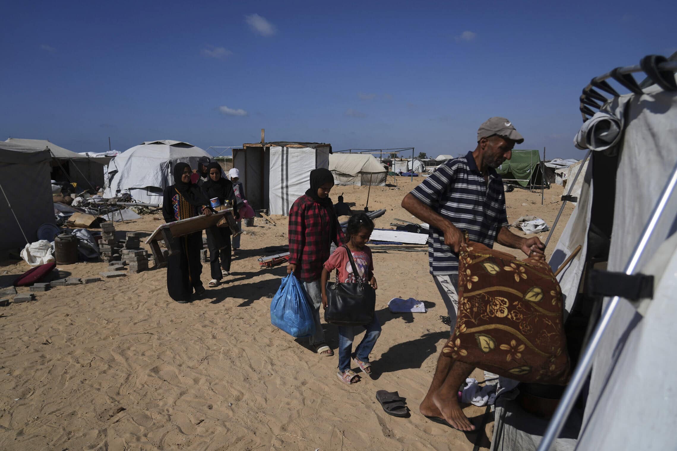 משפחת אבו ג'ראד מתפנה שוב לאוהל חדש בחאן יונס אחרי שנאלצו לעזוב את העיר עזה, 11 בספטמבר 2025 (צילום: AP Photo/Abdel Kareem Hana)