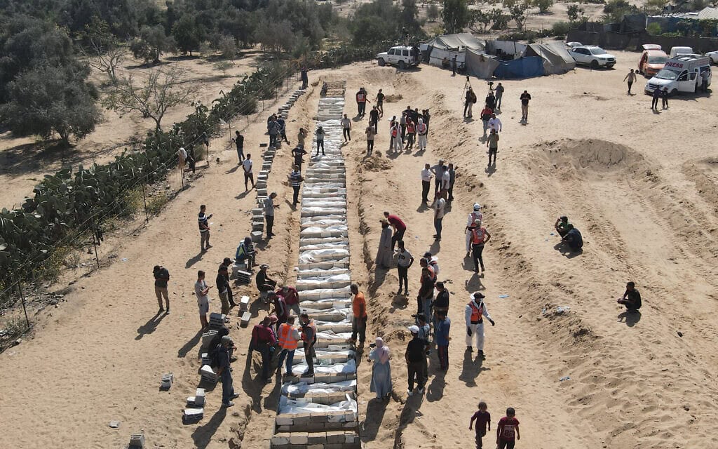פלסטינים קוברים 54 גופות לא מזוהות שהוחזרו על ידי ישראל בקבר אחים בדיר אל־בלח, שבמרכז רצועת עזה, ב־22 באוקטובר 2025, (צילום: AFP) פלסטינים קוברים 54 גופות לא מזוהות שהוחזרו על ידי ישראל בקבר אחים בדיר אל־בלח, שבמרכז רצועת עזה, ב־22 באוקטובר 2025, (צילום: AFP)
