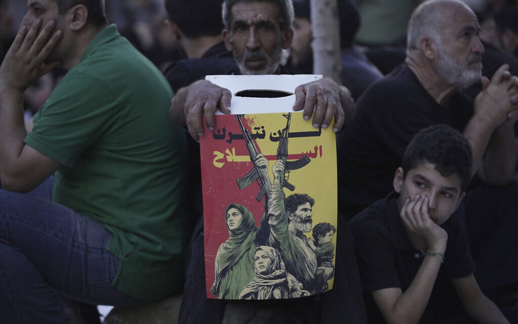 תומך חזבאללה אוחז בפוסטר שאומר "לא נוותר על נשקינו" בביירות, לבנון, 6 ביולי 2025 (צילום: AP Photo/Hassan Ammar) תומך חזבאללה אוחז בפוסטר שאומר "לא נוותר על נשקינו" בביירות, לבנון, 6 ביולי 2025 (צילום: AP Photo/Hassan Ammar)