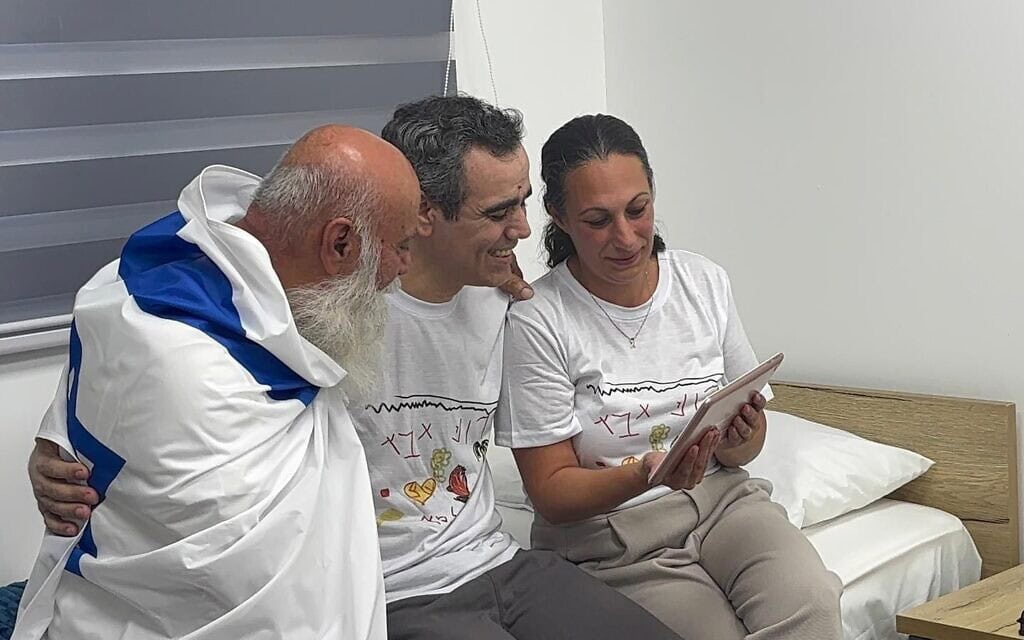 עמרי מירן לצד אשתו לישי ואביו דני, בזמן שהוא משוחח עם בנותיו לראשונה מזה למעלה משנתיים, עם חזרתו משבי חמאס לבסיס רעים. 13 באוקטובר 2025 (צילום: פורום משפחות החטופים) עמרי מירן לצד אשתו לישי ואביו דני, בזמן שהוא משוחח עם בנותיו לראשונה מזה למעלה משנתיים, עם חזרתו משבי חמאס לבסיס רעים. 13 באוקטובר 2025 (צילום: פורום משפחות החטופים)