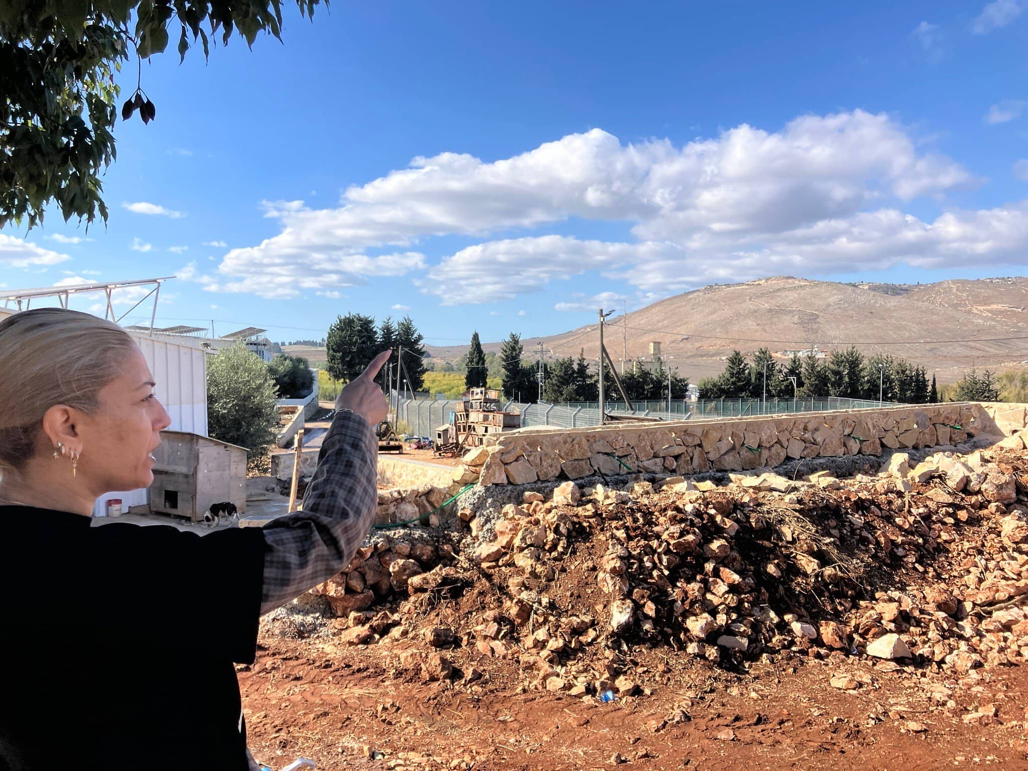 לימור ביטון מצביעה על בינת ג'בייל בלבנון מחצר ביתה במושב אביבים, 26 בנובמבר 2025 (צילום: דיאנה בלטר) לימור ביטון מצביעה על בינת ג'בייל בלבנון מחצר ביתה במושב אביבים, 26 בנובמבר 2025 (צילום: דיאנה בלטר)