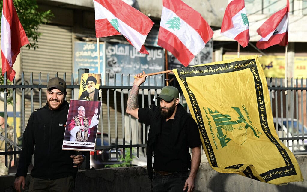 תומכי חזבאללה מחזיקים בדגל הארגון ובשלטים המברכים את האפיפיור לאו ה־14 ברובע הדאחייה בביירות, לבנון, 30 בנובמבר 2025 (צילום: Giuseppe CACACE / AFP) תומכי חזבאללה מחזיקים בדגל הארגון ובשלטים המברכים את האפיפיור לאו ה־14 ברובע הדאחייה בביירות, לבנון, 30 בנובמבר 2025 (צילום: Giuseppe CACACE / AFP)