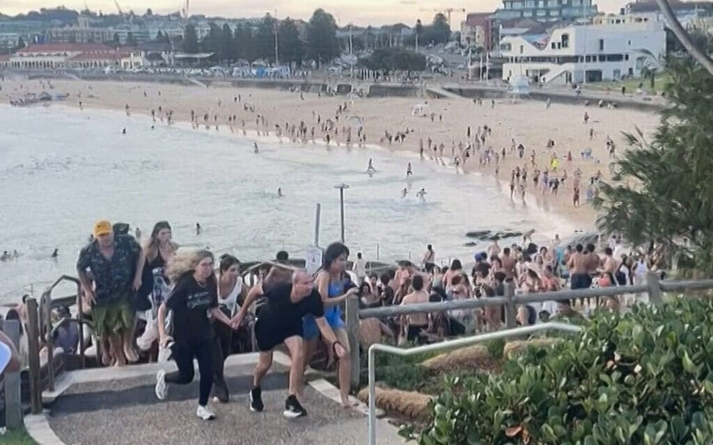 המונים נמלטים מחוף בונדיי באוסטרליה בזמן הפיגוע, 14 בדצמבר 2025 (צילום: Photo by Mike Ortiz / UGC / AFP) המונים נמלטים מחוף בונדיי באוסטרליה בזמן הפיגוע, 14 בדצמבר 2025 (צילום: Photo by Mike Ortiz / UGC / AFP)