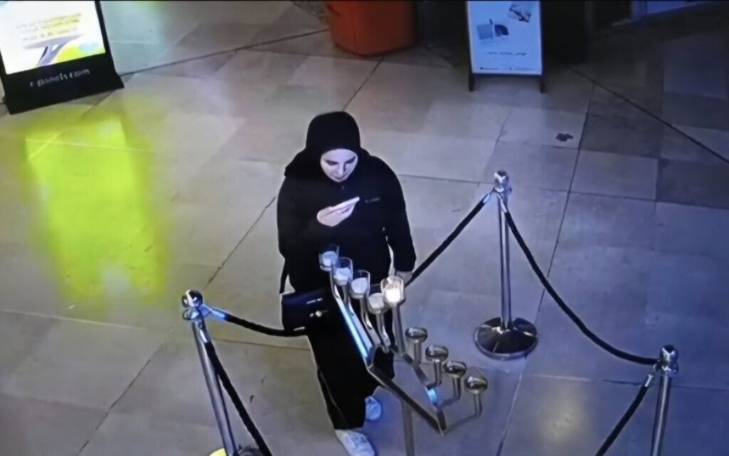 אישה מוסלמית מכבה נרות חנוכה בקניון ויצמן בתל אביב, 20 בדצמבר 2025