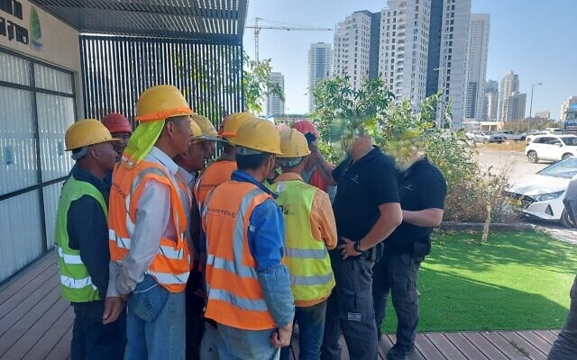 עובדי מנהל אכיפה ברשות האוכלוסין משוחחים עם עובדים זרים