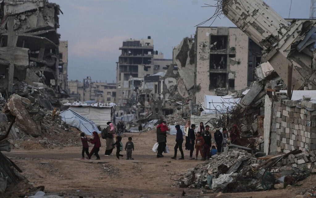 פלסטינים צועדים בין מבנים הרוסים בשכונת זייתון בעיר עזה, 14 בינואר 2026 (צילום: AP Photo/Jehad Alshrafi) פלסטינים צועדים בין מבנים הרוסים בשכונת זייתון בעיר עזה, 14 בינואר 2026 (צילום: AP Photo/Jehad Alshrafi)