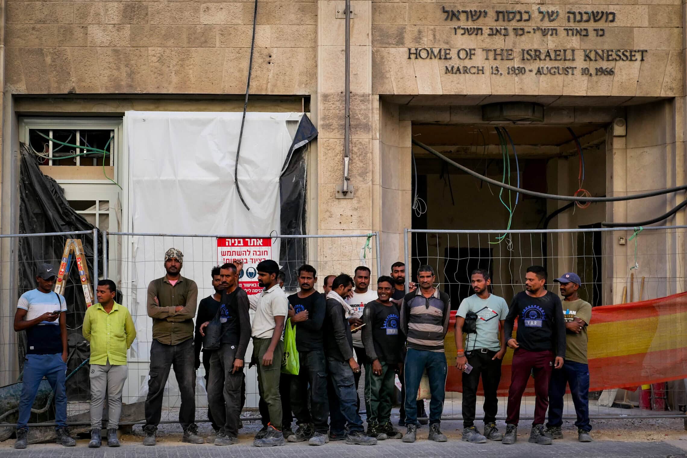 עובדי בנייה זרים עומדים מחוץ למוזיאון הכנסת בזמן בנייתו, 28 ביולי 2024 (צילום: נתי שוחט/פלאש90) עובדי בנייה זרים עומדים מחוץ למוזיאון הכנסת בזמן בנייתו, 28 ביולי 2024 (צילום: נתי שוחט/פלאש90)