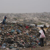 ילדים פלסטינים אוספים פלסטיק ונייר כדי לשרוף לצורכי בישול וחימום במזבלה בחאן יונס, 22 בינואר 2026 (צילום: AP Photo/Jehad Alshrafi) ילדים פלסטינים אוספים פלסטיק ונייר כדי לשרוף לצורכי בישול וחימום במזבלה בחאן יונס, 22 בינואר 2026 (צילום: AP Photo/Jehad Alshrafi)