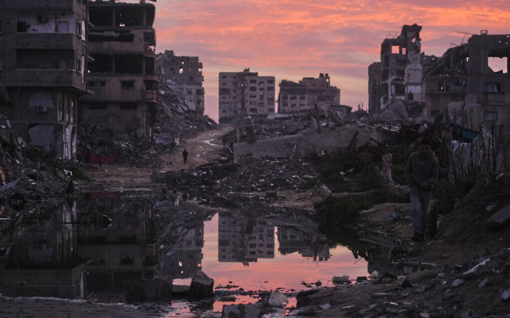 פלסטינים צועדים בין מבנים שנהרסו בתקיפות אוויריות וקרקעיות של ישראל בעיר עזה, 29 בינואר 2026 (צילום: AP Photo/Jehad Alshrafi) פלסטינים צועדים בין מבנים שנהרסו בתקיפות אוויריות וקרקעיות של ישראל בעיר עזה, 29 בינואר 2026 (צילום: AP Photo/Jehad Alshrafi)