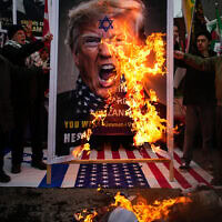 מפגינים שורפים כרזה של נשיא ארה"ב דונלד טראמפ במהלך עצרת אנטי־אמריקאית ואנטי־ישראלית, מחוץ לקונסוליה האמריקאית באיסטנבול, 1 בפברואר 2026