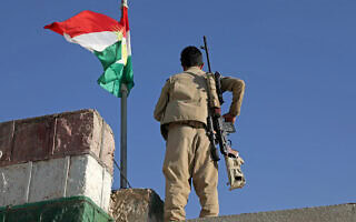 לוחם פשמרגה כורדי המזוהה עם המפלגה הדמוקרטית של כורדיסטאן האיראנית (KDP-Iran) עומד על המשמר על גג בניין לאחר תקיפה איראנית חוצת גבול בעיירה קויה (קוייסנג’ק), 100 קילומטרים ממזרח לארביל, בירת החבל הכורדי האוטונומי בצפון עיראק, ב-1 באוקטובר 2022. (צילום: Safin HAMID / AFP) לוחם פשמרגה כורדי המזוהה עם המפלגה הדמוקרטית של כורדיסטאן האיראנית (KDP-Iran) עומד על המשמר על גג בניין לאחר תקיפה איראנית חוצת גבול בעיירה קויה (קוייסנג’ק), 100 קילומטרים ממזרח לארביל, בירת החבל הכורדי האוטונומי בצפון עיראק, ב-1 באוקטובר 2022. (צילום: Safin HAMID / AFP)