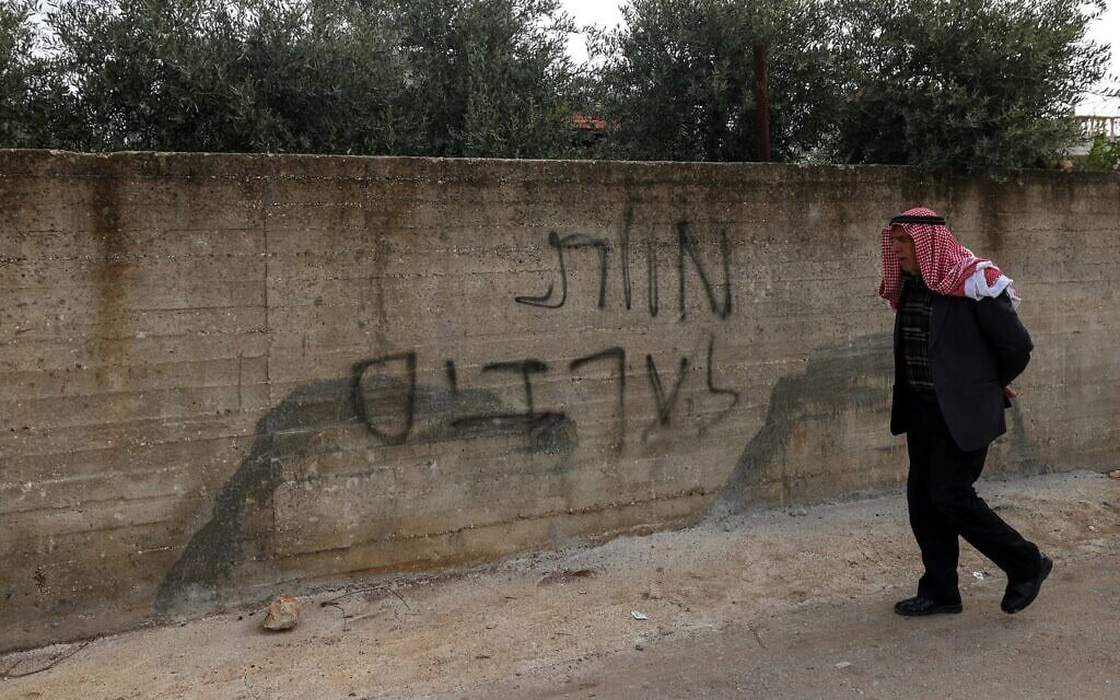 גרפיטי "מוות לערבים" שרוסס על חומת בית בכפר דיר אל-ח'טב, מזרחית לעיר שכם בגדה המערבית. 22 במרץ 2026 (צילום: JAAFAR ASHTIYEH / AFP)