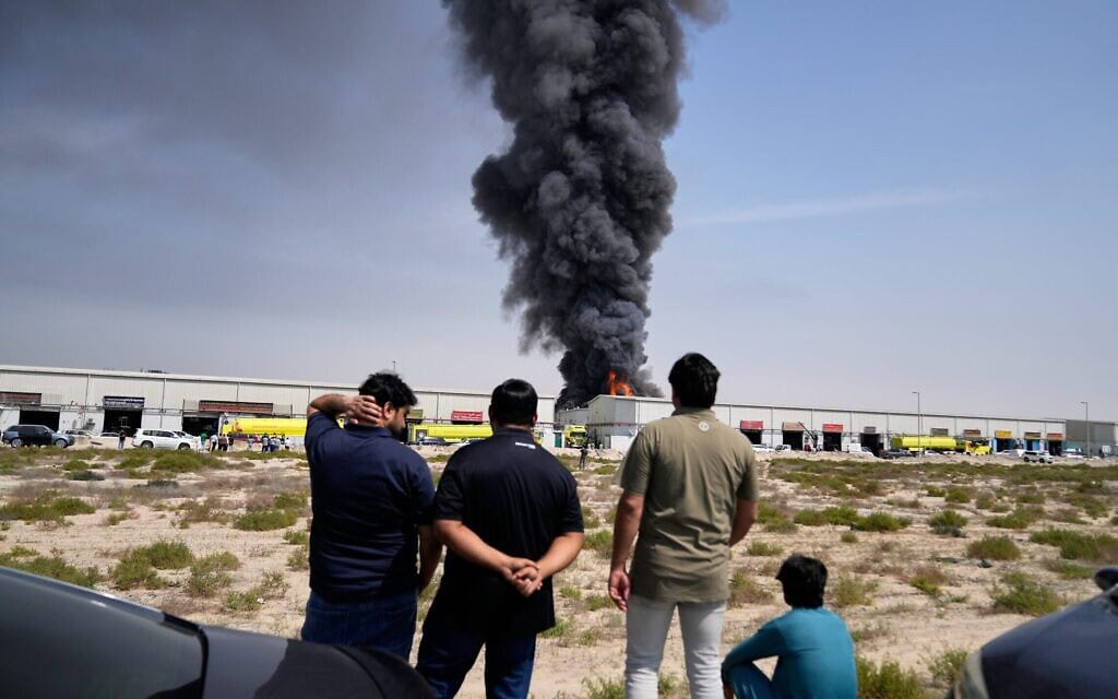 תושבי איחוד האמירויות צופים בלהבות ובעמוד עשן העולה ממחסן באזור התעשייה של העיר שארג'ה, שהותקף על ידי איראן, 1 במרץ 2026 (צילום: AP Photo/Altaf Qadri) תושבי איחוד האמירויות צופים בלהבות ובעמוד עשן העולה ממחסן באזור התעשייה של העיר שארג'ה, שהותקף על ידי איראן, 1 במרץ 2026 (צילום: AP Photo/Altaf Qadri)