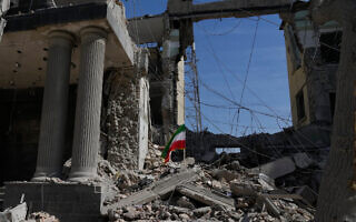 דגל איראן מבצבץ בין ההריסות של מתקן איראני שנפגע במהלך המערכה הצבאית של ארה"ב וישראל בטהרן, 4 במרץ 2026 (צילום: AP Photo/Vahid Salemi) דגל איראן מבצבץ בין ההריסות של מתקן איראני שנפגע במהלך המערכה הצבאית של ארה"ב וישראל בטהרן, 4 במרץ 2026 (צילום: AP Photo/Vahid Salemi)