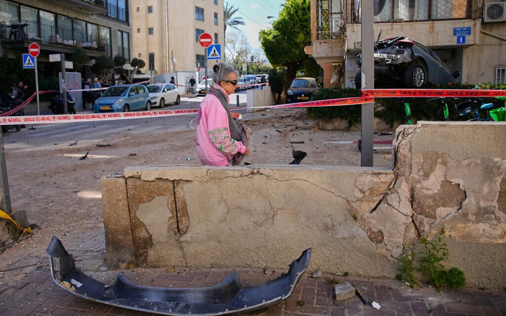 אישה חולפת לצד אזור שנסגר וניזוק במהלך תקיפה איראנית בתל אביב, ישראל, יום ראשון, 8 במרץ 2026 (צילום: AP Photo/Ohad Zwigenberg) אישה חולפת לצד אזור שנסגר וניזוק במהלך תקיפה איראנית בתל אביב, ישראל, יום ראשון, 8 במרץ 2026 (צילום: AP Photo/Ohad Zwigenberg)