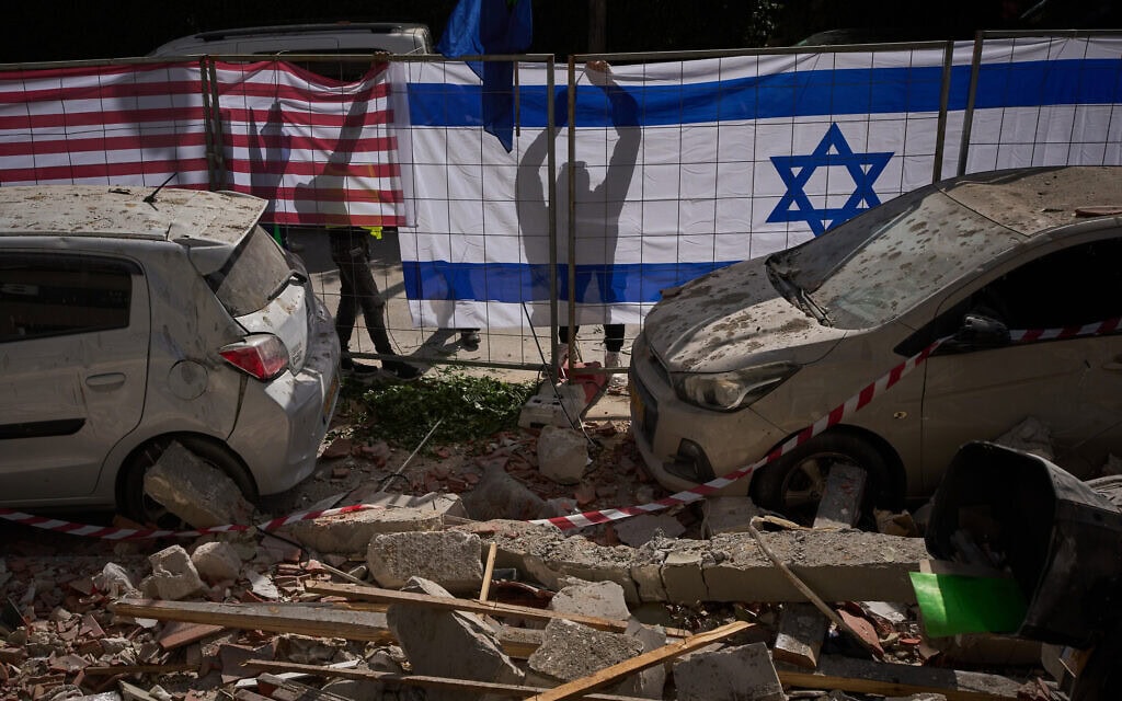 דגלי ישראל וארה״ב נתלים בזירת פגיעת טיל איראני ברמת גן. 18 במרץ 2026 (צילום: AP Photo/Oded Balilty) דגלי ישראל וארה״ב נתלים בזירת פגיעת טיל איראני ברמת גן. 18 במרץ 2026 (צילום: AP Photo/Oded Balilty)