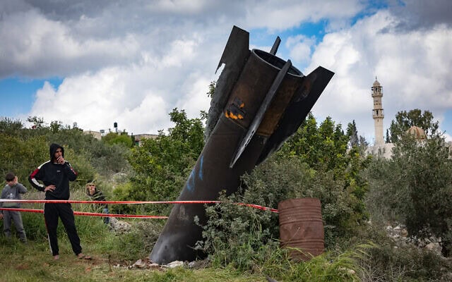 פלסטינים בוחנים שרידים של טיל בליסטי ששוגר מאיראן לעבר ישראל ונפל מחוץ לכפר הפלסטיני חארס שבגדה המערבית. 24 במרץ 2026