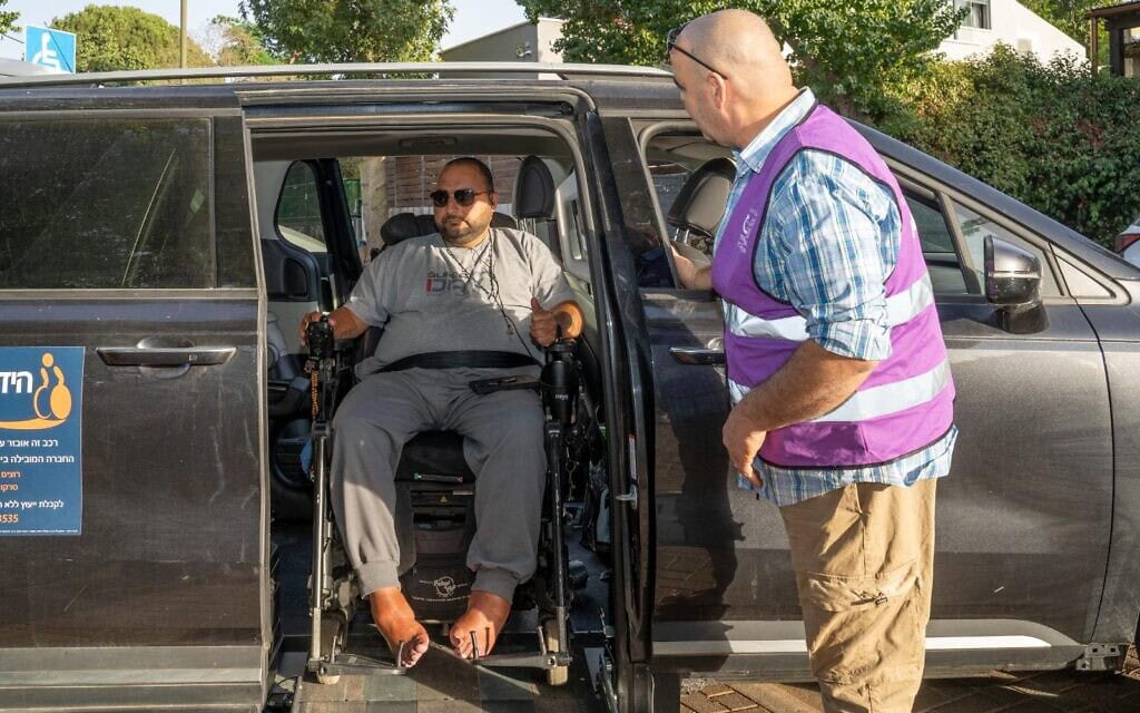 מתנדב "האפוד האפור" מסייע לאדם עם מוגבלויות (צילום: "נגישות ישראל") מתנדב "האפוד האפור" מסייע לאדם עם מוגבלויות (צילום: "נגישות ישראל")