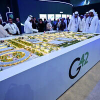 אורחים מביטים בדגם של מרכז הנתונים הגדול ביותר באיחוד האמירויות, הנבנה באבו דאבי במסגרת יוזמת Stargate, מיזם משותף של G42, מיקרוסופט ו-OpenAI, במהלך תערוכת וכנס הנפט הבינלאומיים של אבו דאבי (ADIPEC) באבו דאבי, ב-3 בנובמבר 2025