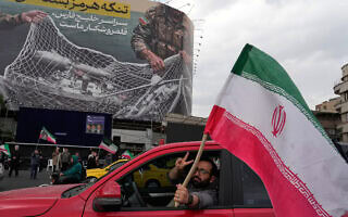 גבר מחזיק דגל איראני מול שלט אנטי־אמריקאי עם הכיתוב: "מצר הורמוז יישאר סגור, כל המפרץ הפרסי הוא שטח הציד שלנו", בכיכר "המהפכה האסלאמית" במרכז טהרן, איראן, 13 באפריל 2026 (צילום: AP Photo/Vahid Salemi) גבר מחזיק דגל איראני מול שלט אנטי־אמריקאי עם הכיתוב: "מצר הורמוז יישאר סגור, כל המפרץ הפרסי הוא שטח הציד שלנו", בכיכר "המהפכה האסלאמית" במרכז טהרן, איראן, 13 באפריל 2026 (צילום: AP Photo/Vahid Salemi)