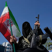 חברת מיליציית הבסיג' מחזיקה בנשקה ובדגל איראן במהלך עצרת שאורגנה על ידי המדינה לתמיכה במנהיג העליון בטהרן, 17 באפריל 2026