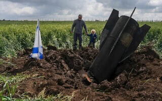 ילד ואביו ליד זנב טיל איראני שיורט בשדה ברמת הגולן. 8 באפריל 2026 (צילום: אייל מרגולין/פלאש90) ילד ואביו ליד זנב טיל איראני שיורט בשדה ברמת הגולן. 8 באפריל 2026 (צילום: אייל מרגולין/פלאש90)