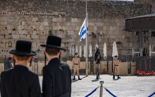 גברים חרדים מביטים בחיילים בכותל ליד דגל שהורד לחצי התורן לציון יום הזיכרון לחללי מערכות ישראל ונפגעי פעולות האיבה, 21.4.2026 (צילום: יונתן זינדל / פלאש90) גברים חרדים מביטים בחיילים בכותל ליד דגל שהורד לחצי התורן לציון יום הזיכרון לחללי מערכות ישראל ונפגעי פעולות האיבה, 21.4.2026 (צילום: יונתן זינדל / פלאש90)