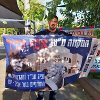 עומר נחמני מציג כרזה עם הכיתוב: "המקווה על שם אסף זמיר", 28 במאי 2026