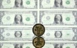 אילוסטרציה: המטבע היציב טתר (USDT) על רקע שטרות דולר אמריקאי (צילום: Justin TALLIS / AFP) אילוסטרציה: המטבע היציב טתר (USDT) על רקע שטרות דולר אמריקאי (צילום: Justin TALLIS / AFP)
