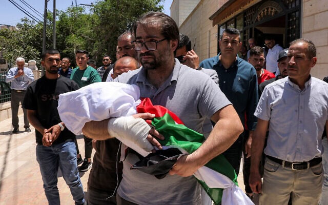 פהאד אבו הייכל נושא את גופת בנו סם, בן שבעה חודשים, שנורה למוות בידי חייל צה"ל, במהלך הלווייתו בחברון, 6 ביוני 2026 (צילום: HAZEM BADER / AFP) פהאד אבו הייכל נושא את גופת בנו סם, בן שבעה חודשים, שנורה למוות בידי חייל צה"ל, במהלך הלווייתו בחברון, 6 ביוני 2026 (צילום: HAZEM BADER / AFP)