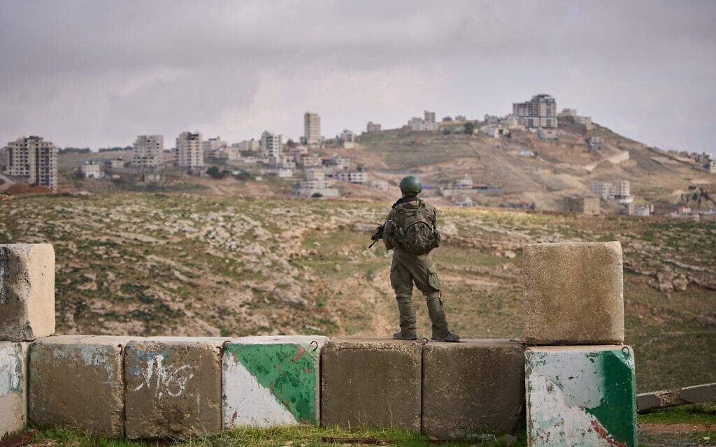חייל עומד על המשמר במהלך טקס החנוכה של ההתנחלות יציב, סמוך לעיירה הפלסטינית בית סאחור שבגדה המערבית, 19 בינואר 2026 (צילום: AP Photo/Ohad Zwigenberg) חייל עומד על המשמר במהלך טקס החנוכה של ההתנחלות יציב, סמוך לעיירה הפלסטינית בית סאחור שבגדה המערבית, 19 בינואר 2026 (צילום: AP Photo/Ohad Zwigenberg)