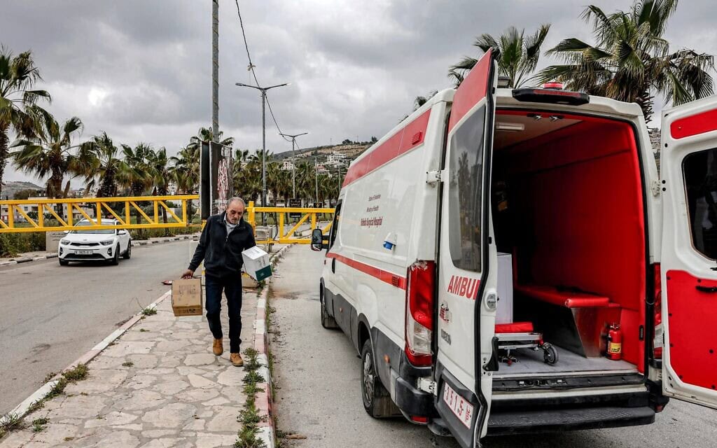 אילוסטרציה: אדם מעביר ארגזי תרופות מבית חולים בשכם לרכב אמבולנס הממתין מאחורי מחסום בכניסה לכפר הפלסטיני תורמוס עיא שבגדה המערבית, 6 במאי 2026 (צילום: Zain JAAFAR / AFP) אילוסטרציה: אדם מעביר ארגזי תרופות מבית חולים בשכם לרכב אמבולנס הממתין מאחורי מחסום בכניסה לכפר הפלסטיני תורמוס עיא שבגדה המערבית, 6 במאי 2026 (צילום: Zain JAAFAR / AFP)
