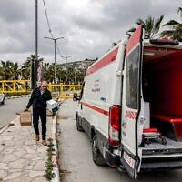 אילוסטרציה: אדם מעביר ארגזי תרופות מבית חולים בשכם לרכב אמבולנס הממתין מאחורי מחסום בכניסה לכפר הפלסטיני תורמוס עיא שבגדה המערבית, 6 במאי 2026