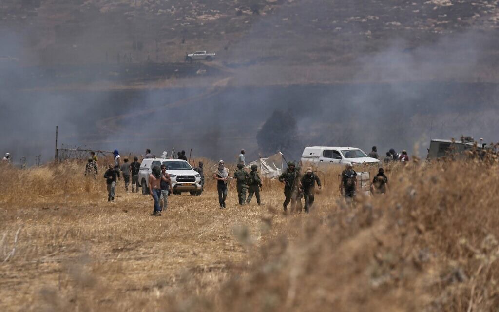 מתנחלים ישראלים מציתים אדמות חקלאיות סמוך לעיירה בית פוריק שבגדה המערבית, 13 ביולי 2026 (צילום: AP/Majdi Mohammed) מתנחלים ישראלים מציתים אדמות חקלאיות סמוך לעיירה בית פוריק שבגדה המערבית, 13 ביולי 2026 (צילום: AP/Majdi Mohammed)