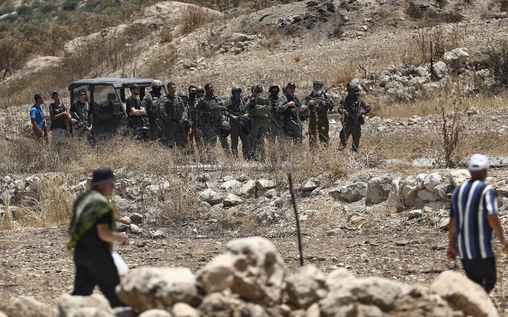 כוחות ביטחון ישראליים מאבטחים את האזור בזמן שפלסטינים מקיימים את תפילת יום שישי, במהלך מחאה נגד הרחבת ההתנחלויות והפקעת אדמות בעיירה אידנא שבגדה המערבית, ליד חברון. 10 ביולי 2026 (צילום: Wisam Hashlamoun/Flash90) כוחות ביטחון ישראליים מאבטחים את האזור בזמן שפלסטינים מקיימים את תפילת יום שישי, במהלך מחאה נגד הרחבת ההתנחלויות והפקעת אדמות בעיירה אידנא שבגדה המערבית, ליד חברון. 10 ביולי 2026 (צילום: Wisam Hashlamoun/Flash90)