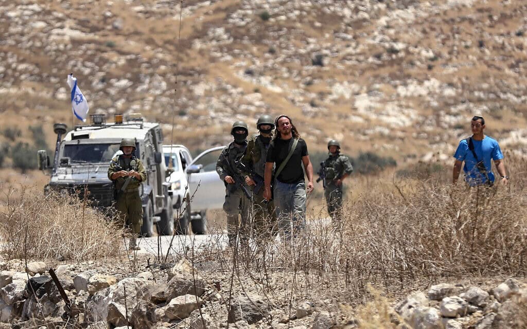 כוחות ביטחון ישראליים מאבטחים את האזור בעוד פלסטינים מקיימים את תפילת יום השישי, במהלך מחאה נגד הרחבת ההתנחלויות והפקעת קרקעות בעיירה אידנא שבגדה המערבית, ליד חברון. 10 ביולי 2026 (צילום: Wisam Hashlamoun/Flash90) כוחות ביטחון ישראליים מאבטחים את האזור בעוד פלסטינים מקיימים את תפילת יום השישי, במהלך מחאה נגד הרחבת ההתנחלויות והפקעת קרקעות בעיירה אידנא שבגדה המערבית, ליד חברון. 10 ביולי 2026 (צילום: Wisam Hashlamoun/Flash90)