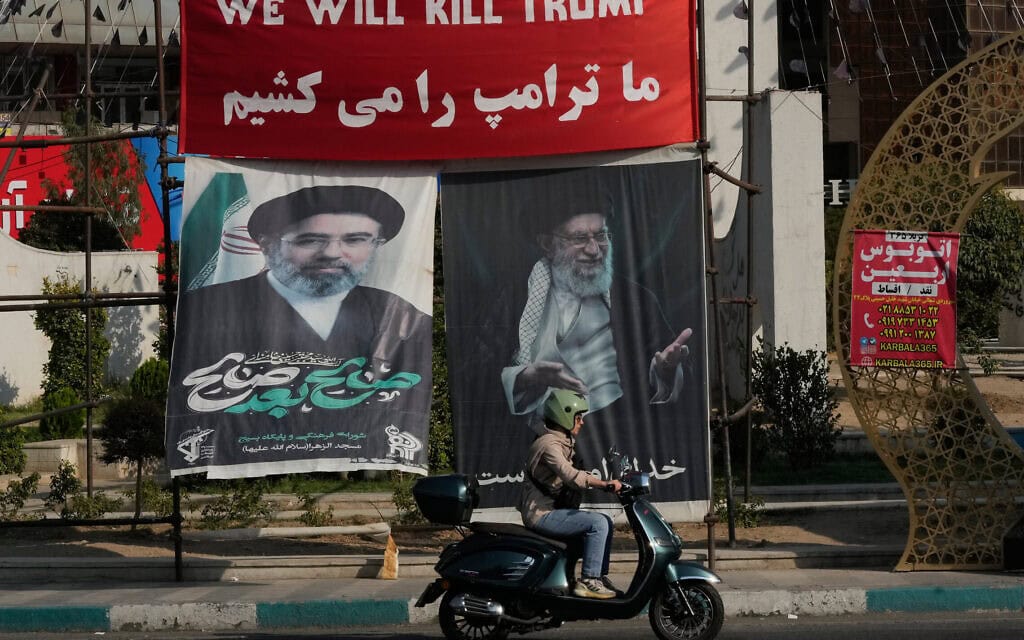 אופנוע חולף על פני כרזה שעליה נכתב באנגלית ובפרסית "נהרוג את טראמפ", וכרזות עם דיוקנאותיהם של מנהיגה העליון המנוח של איראן, אייתוללה עלי חמינאי (מימין), ובנו ויורשו, אייתוללה מוג'תבא חמינאי, בכיכר בטהרן, 10 באוגוסט 2026 (צילום: AP Photo/Vahid Salemi) אופנוע חולף על פני כרזה שעליה נכתב באנגלית ובפרסית "נהרוג את טראמפ", וכרזות עם דיוקנאותיהם של מנהיגה העליון המנוח של איראן, אייתוללה עלי חמינאי (מימין), ובנו ויורשו, אייתוללה מוג'תבא חמינאי, בכיכר בטהרן, 10 באוגוסט 2026 (צילום: AP Photo/Vahid Salemi)