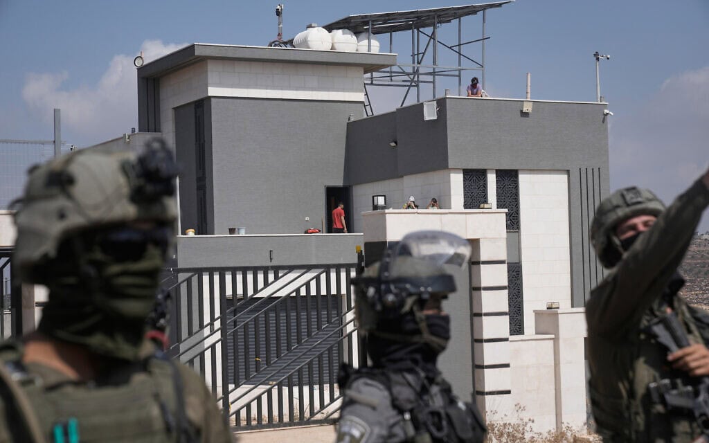חיילי צה"ל חוסמים את הדרך המובילה לבתיהן של שלוש משפחות פלסטיניות הנצורות בידי מתנחלים זה שישה ימים, בעת שפעילים צועדים כדי להעביר אספקת מזון ומים לתושבים, בכפר קוסרה שמדרום לשכם בגדה המערבית. (צילום: AP Photo/Majdi Mohammed)