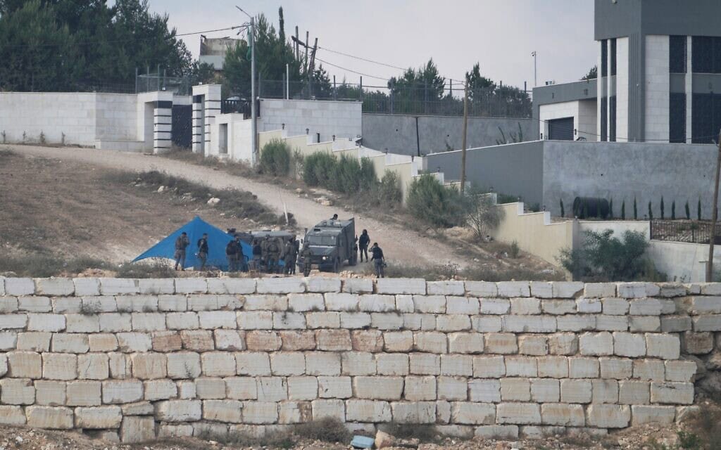 חיילים מפנים מתנחלים, לפני פירוק האוהל שלהם, ליד אחד משלושת הבתים של משפחות פלסטיניות הנתונות במצור של מתנחלים זה שישה ימים, בקוסרה שבגדה המערבית, 14 באוגוסט 2026 (צילום: AP Photo/Majdi Mohammed) חיילים מפנים מתנחלים, לפני פירוק האוהל שלהם, ליד אחד משלושת הבתים של משפחות פלסטיניות הנתונות במצור של מתנחלים זה שישה ימים, בקוסרה שבגדה המערבית, 14 באוגוסט 2026 (צילום: AP Photo/Majdi Mohammed)