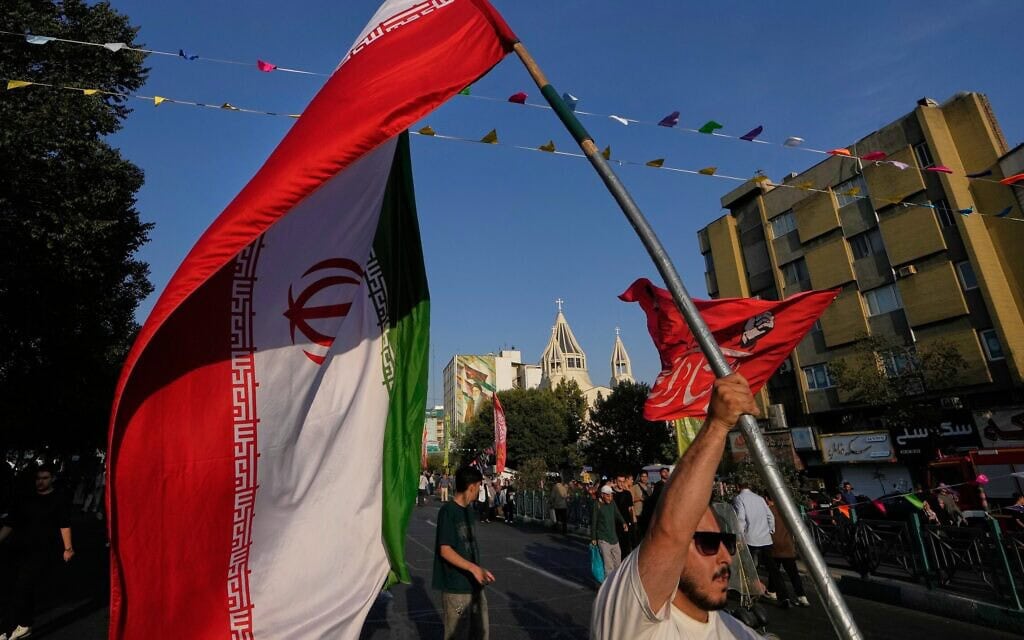 גבר אוחז בדגל איראן במהלך חגיגות רחוב לציון יום הולדתו של הנביא מוחמד, כשברקע קתדרלת סנט סרקיס הארמנית בטהרן. 30 באוגוסט 2026 (צילום: AP Photo/Vahid Salemi) גבר אוחז בדגל איראן במהלך חגיגות רחוב לציון יום הולדתו של הנביא מוחמד, כשברקע קתדרלת סנט סרקיס הארמנית בטהרן. 30 באוגוסט 2026 (צילום: AP Photo/Vahid Salemi)